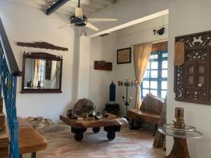 a living room with a ceiling fan and a table at Casa de Playa Madeleyne in Taganga