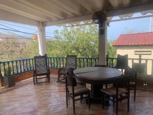 a patio with a table and chairs on a balcony at Casa de Playa Madeleyne in Taganga