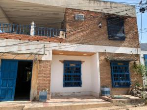 an old brick house with blue doors and windows at Casa de Playa Madeleyne in Taganga +2 photos