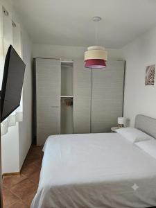a bedroom with a large white bed and a pink lamp at La sosta di Strada in Strada