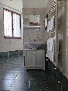 a bathroom with a white sink and a tiled floor at La sosta di Strada in Strada