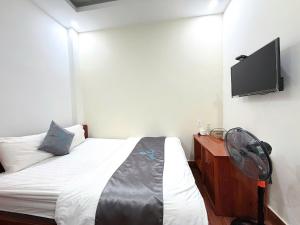 a bedroom with a bed with a fan and a tv at CaRa Hotel Đà Lạt in Da Lat +36 photos