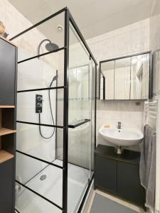 a bathroom with a glass shower and a sink at Le Ptit Roc, cocon cosy in Chailles +13 photos