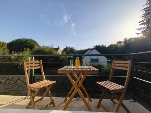 two chairs and a wooden table on a patio at Villa Anita in Chevreuse