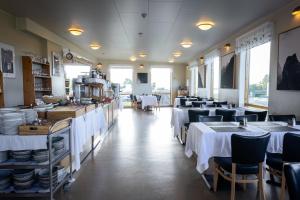 a restaurant with tables and chairs with white table cloth at Hali Country Hotel in Gerdi