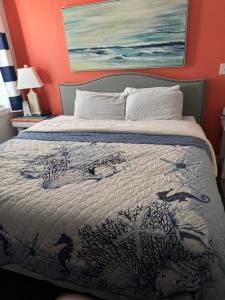 a bedroom with a bed with a painting on the wall at Golf Glenn Villa A205 in Myrtle Beach +14 photos