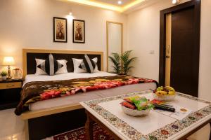 a bedroom with a bed and a table with fruits on it at Hotel Bed & Room in Agra