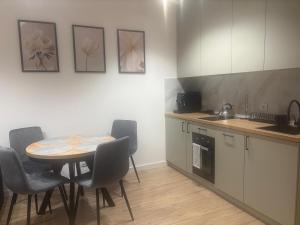 a kitchen with a table and chairs and a table and a counter at Noir2 Gniezno in Gniezno