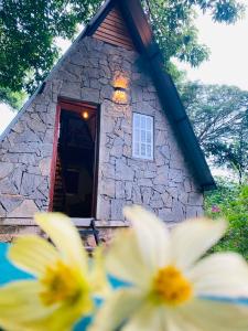 a stone building with a window and some flowers at Saruketha Cabana in Kegalle