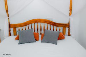 a bed with orange and gray pillows on it at The Fort House - Matara in Matara