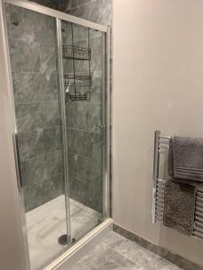a shower with a glass door in a bathroom at Stylish apartment in Halifax in Halifax +42 photos