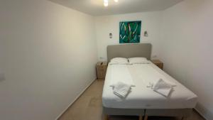 a bedroom with a white bed and a painting on the wall at Holiday Home Traum in Krk +26 photos