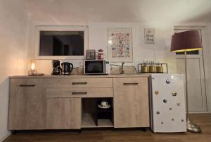 a kitchen with a counter with a microwave and a refrigerator at Atia Residence in Sibiu