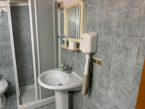 a bathroom with a sink and a phone on the wall at Hotel Tania in Casa Giosafat