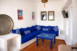 a blue couch in a living room with a table at Dar Zambra in Chefchaouen