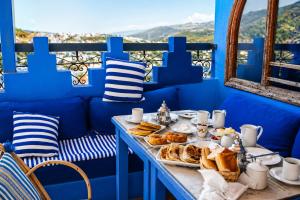 a table with bread and pastries in a blue room at Dar Zambra in Chefchaouen