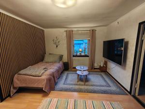a small bedroom with a bed and a table at Muminhuset i Norberg in Norberg