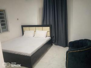 a bed with white pillows in a room with a window at AAJBLissful in Idowu