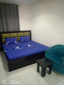 a bedroom with a bed and a chair at AAJBLissful in Idowu