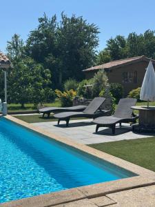 a swimming pool with two lounge chairs and a table at Maison L'étalonblanc in Tupin-et-Semons