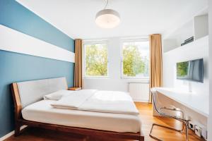 a bed in a room with a blue wall at Brera Nürnberg in Nuremberg