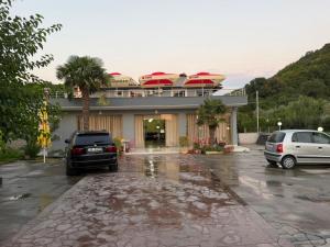 two cars parked in a parking lot in front of a building at Hotel, Bar, Restaurant Beni in Vlorë +21 photos