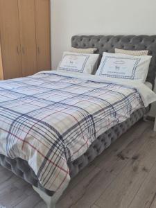 a bed with a blanket and pillows on it at Apartmani Banja Vrujci Lux in Gornja Toplica