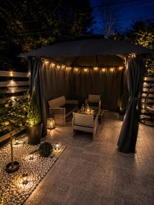 a gazebo with a table and lights on a patio at Maison Royale in Otopeni