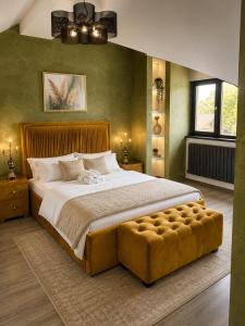a bedroom with a large bed with a brown tufted foot board at Maison Royale in Otopeni