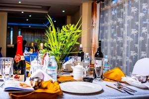 a table with plates and glasses and bottles of wine at Armaflex hotel SMC LTD in Lira