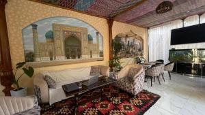a living room with a bed and a table with chairs at Mahalla Old City Samarkand in Samarkand