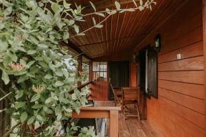 a porch of a house with a table and chairs at Dom wakacyjny Podlas in Żywiec