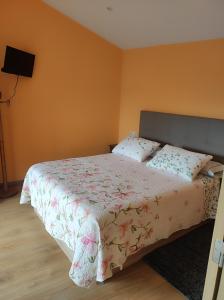 a bedroom with a bed with a floral bedspread at Casa Souto in Santa Comba