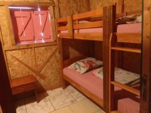 a room with three bunk beds and a window at Gite Chez Théo in Saint-Paul