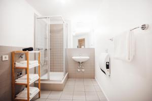 a white bathroom with a shower and a sink at Brera Nürnberg in Nuremberg +27 photos
