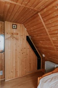 a bedroom with wooden walls and a bed in a room at Dom wakacyjny Podlas in Żywiec