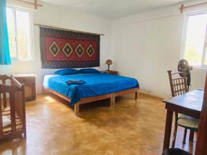 a bedroom with a bed with a blue comforter at Macondo GuestHouse Beach in Playa Estacahuite