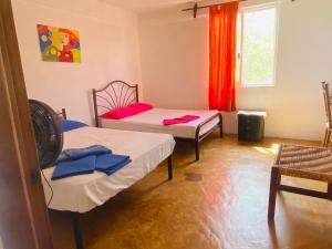 a room with two beds and a window at Macondo GuestHouse Beach in Playa Estacahuite