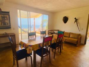 a dining room with a table and chairs and a couch at Macondo GuestHouse Beach in Playa Estacahuite