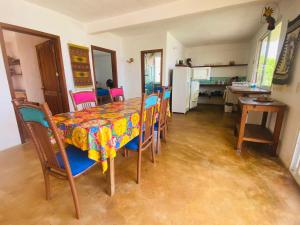 a dining room with a table and chairs and a kitchen at Macondo GuestHouse Beach in Playa Estacahuite