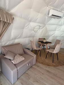 a living room with a couch and a table in a tent at Glamping Bieszczadzki Amor in Zawóz