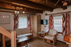 a living room with two chairs and a table and a television at Dom wakacyjny Podlas in Żywiec