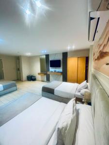 a large hotel room with two beds and a television at lotus view El tahrir in Cairo