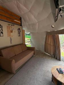 a living room with a couch in a tent at Glamping Bieszczadzki Amor in Zawóz