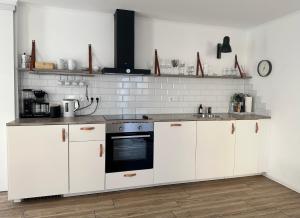 a kitchen with white cabinets and a black oven at Appartement Weiss in Essing +11 photos