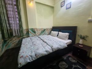 a bedroom with a bed with a white comforter at North Queen Homestay in Darjeeling +7 photos