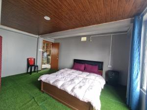 a bedroom with a bed with a wooden ceiling at North Queen Homestay in Darjeeling