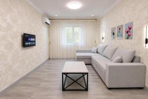 a living room with a couch and a table at Cozy Apartment on the First Floor in Yunusobod
