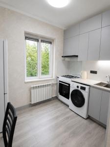 a kitchen with a washing machine and a stove at Cozy Apartment on the First Floor in Yunusobod +8 photos