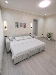 a large bedroom with a large white bed in it at Cozy Apartment on the First Floor in Yunusobod